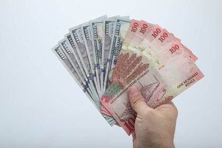 Fan of money  dollar and riyals in male hands isolated on white.の写真素材