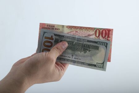 Fan of money  dollar and riyals in male hands isolated on white.