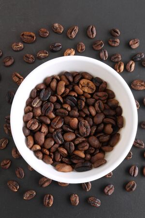 Coffee beans and bowl on stone background. Top view with copy space for your textの写真素材