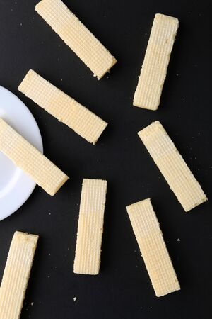Tasty wafer sticks on yellow background, flat lay. Sweet foodの写真素材