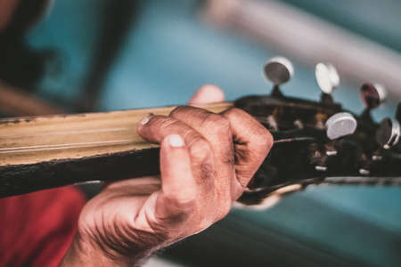 Close-up of a man's hands playing the guitar. Selective focus.の写真素材