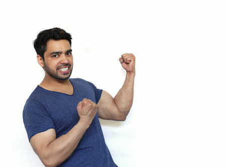 Young Indian Successful man celebrating with arms up - isolated over whiteの写真素材