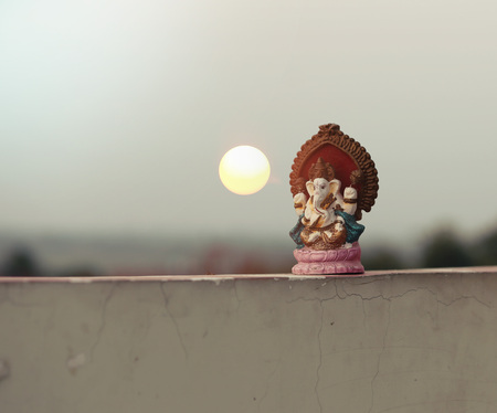 Beautiful idols of Lord Ganesha isolated on a sunset backgroundの写真素材
