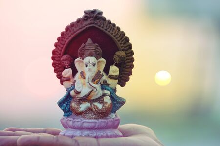 Beautiful idols of Lord Ganesha isolated on a sunset background.の写真素材