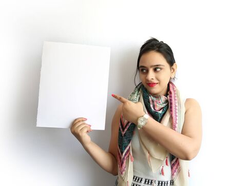 Beautiful indian woman pointing her finger with holding a blank signboard, isolated on white backgroundの写真素材