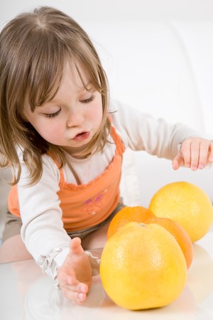 happy little girl with fruitsの写真素材