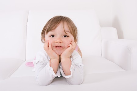 happy little girl on white sofa