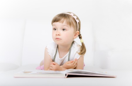sweet happy little girl reading bookの写真素材