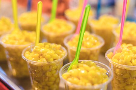 Yellow boil corn that sheath out to put in cup, so cup of corn will mix with some sugas and sweet...