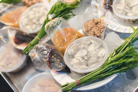 Oyster packing in plastic box selling in a set with sauce and side dishの写真素材