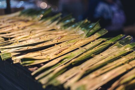 sweet Thai dessert put inside leaves and grillの写真素材