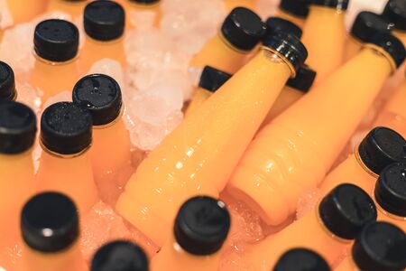 orange juice 100 percent fill up in small long bottle and freezing on iceの写真素材