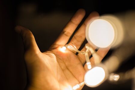 LED light bulb on hand with bokehの写真素材