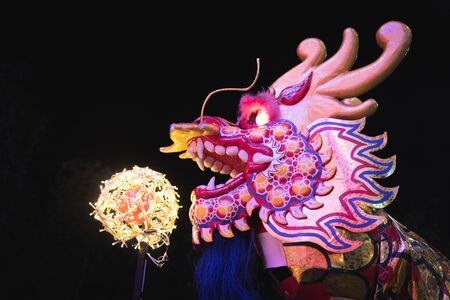dragon head model with a light ball in chinese new year festival at nightの写真素材
