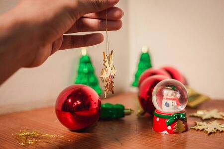 close up snow flake holding by hand with others and christmas decor