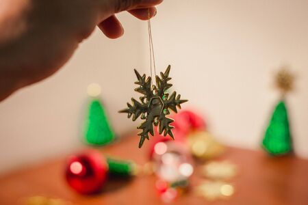 close up snow flake holding by hand with others and christmas decorの写真素材