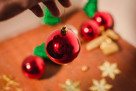 close up red ball holding by hand to align with others and christmas decorの写真素材