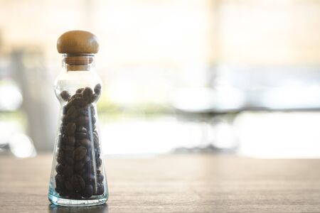 coffee seeds in vintage bottle like science lap bottle put on table for decoration in the cafe