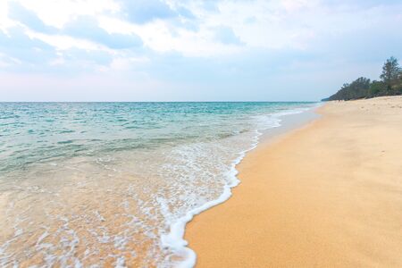 Clean sand on the beach have sea wave coming up diagonal to island, with soft blue sky with cloudyの写真素材