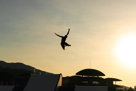 Man slide from top to jump up so high at water park with sunset lightの写真素材