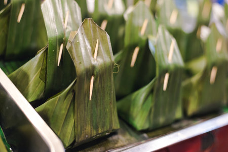 Thai dessert that cover snack inside with banana leaf and seal with a toothpickの写真素材