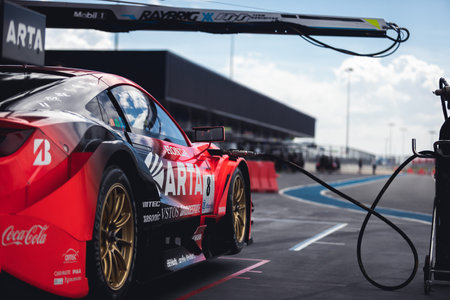 Buriram, Thailand - 28 June 2019 : Thailand SuperGT racing match, One of Japanese team - Arta, still preparing their team racing car, park it into the pit stop and fill fuel or gas in the day with blue skyのeditorial素材