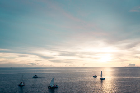 Golden sunset shine over the sea with sailboatsの写真素材