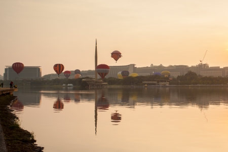 PUTRAJAYA, MALAYSIA - MARCH 30  Colourful and multi shaped hot air balloons floating over foggy sunrise skies at the 5th Putrajaya International Hot Air Balloon Fiesta in Putrajaya, Malaysia on March 30, 2013 のeditorial素材