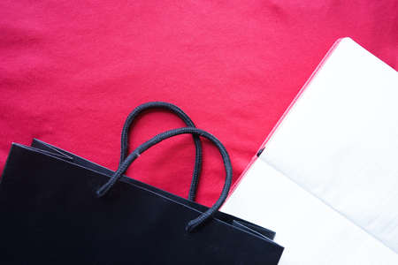 Shopping bag with note book on red backgroundの写真素材
