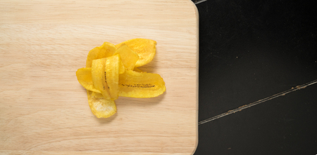 Fried banana chips on a wooden backgroundの写真素材