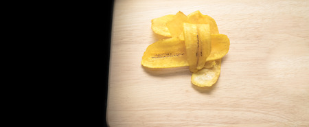 Fried banana chips on a wooden backgroundの写真素材