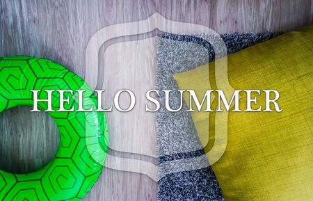 Life buoy over wooden deck with the phrase "HELLO SUMMER"の写真素材