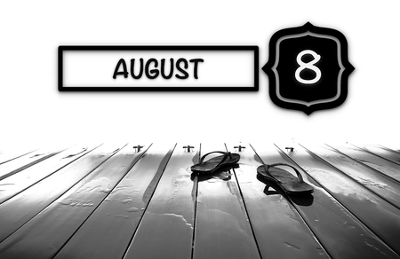 Flip-flop on wooden deck with AUGUST word-Calendar Conceptの写真素材