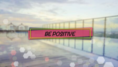 Word BE POSITIVE on blurred background of sunrise over an infinity swimming poolの写真素材