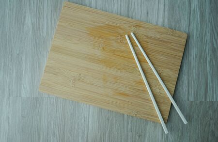 Chopsticks and chopping board on wooden table -COPY SPACEの写真素材
