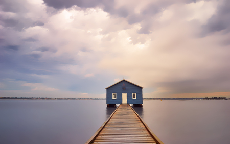 Dramatic sunrise over boathouse in the Swan River Perth, Australiaの写真素材