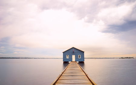 Dramatic sunrise over boathouse in the Swan River Perth, Australiaの写真素材