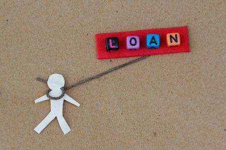 Human cut out with rope around its neck with text LOAN. Concept of human being chained by loan and financial crisis.の写真素材