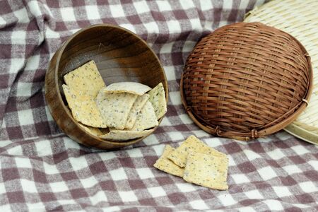 Whole grain crackers / crispy bread in wooden bowl on the table in the kitchenの写真素材