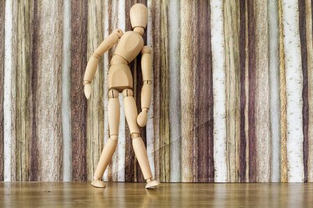 Wooden ball-jointed doll pose in awkward manner, concept of fatique,illness,tiredness,healthの写真素材