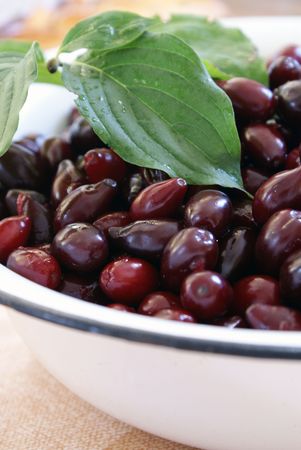 ripe cornelian cherries with leaf in enamel wareの写真素材