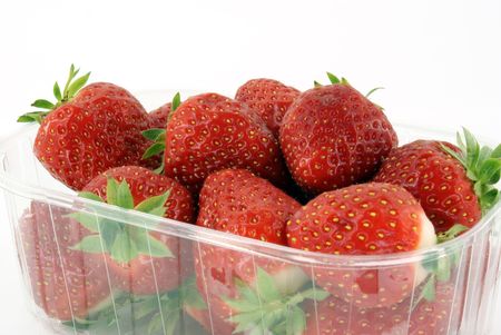 ripe strawberries in plastic container against white backgroundの写真素材