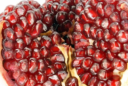 pomegranate cut into sections against white backgroundの写真素材