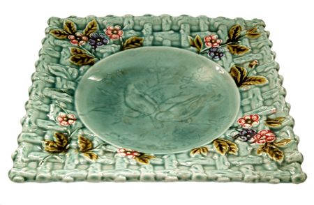 old plate with foliage against white backgroundの写真素材