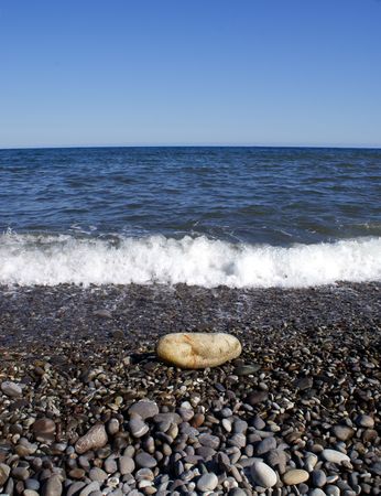 alone stone on beach against pebblesの写真素材