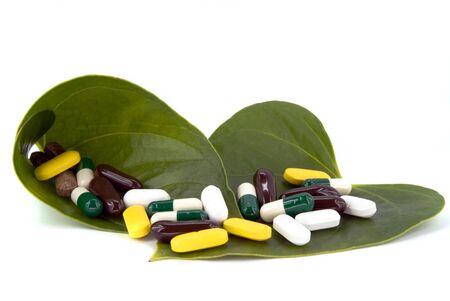 pills in green leaf on white background