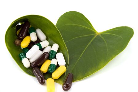 pills in green leaf on white backgroundの写真素材