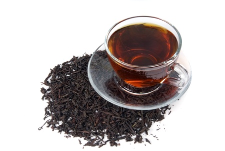 cup with tea on heap of tea leafの写真素材