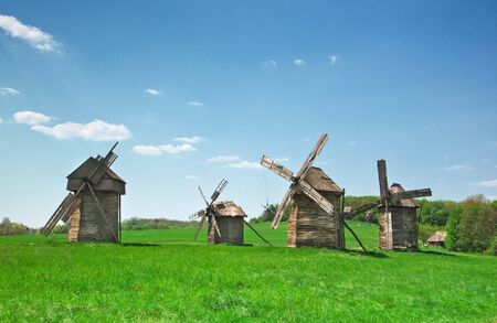 ancient windmills in field against skyの写真素材