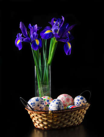 Easter eggs with bouquet of iris in dark